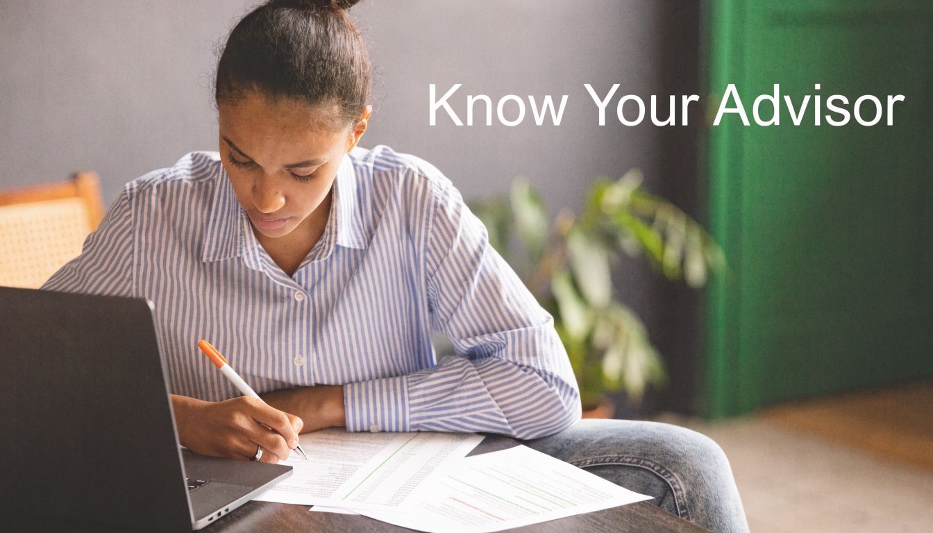 A woman studying at a desk with a laptop and documents while searching for her financial advisor.